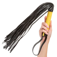 black and yellow flogger held in hand