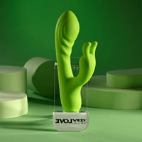 Green rabbit vibrator on a clear stand with 'Evolved' branding against a green background