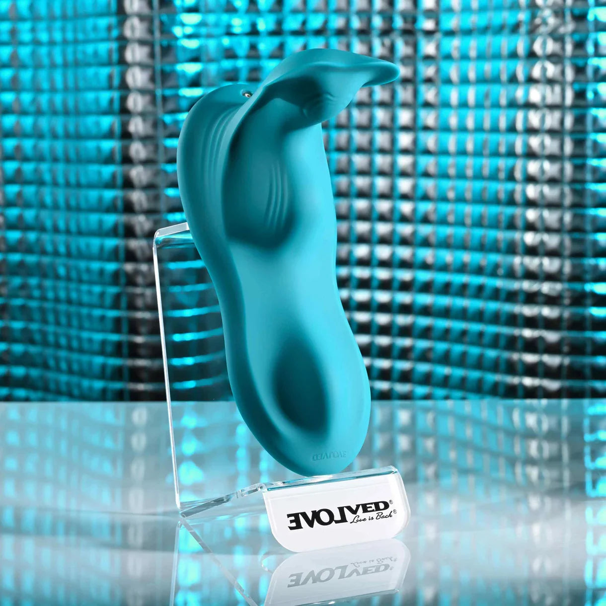 Turquoise silicone grinder pad on a clear stand with 'EvolvEd' branding against a blue mosaic background