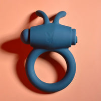 Blue silicone ring with a Playboy logo on a peach background