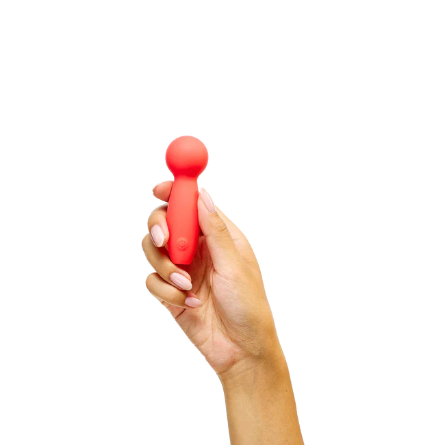 Hand holding a red handheld massager against a white background