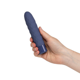 A hand holding a dark blue textured silicone personal massager against a plain white background.