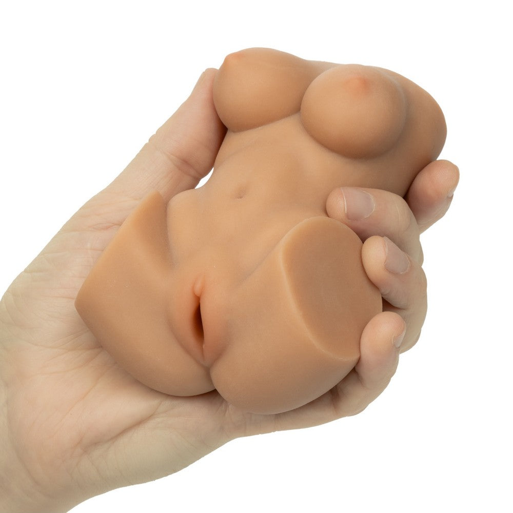 A realistic flesh-toned silicone adult masturbator toy being held in a hand against a plain white background.
