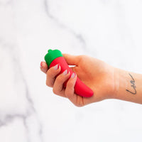 red chili pepper vibrator with green top held in hand