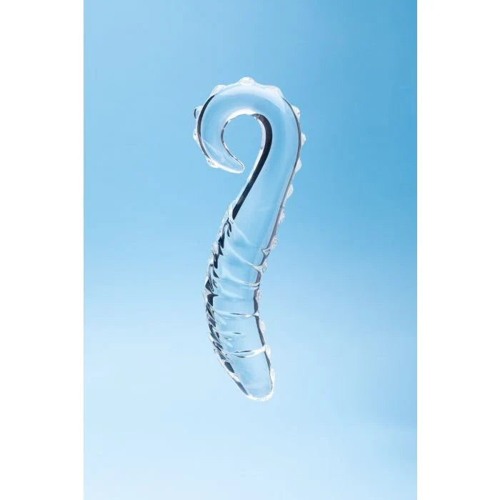 A clear, transparent glass curved hook-shaped dildo with a ribbed textured body, shown against a soft light blue gradient background.