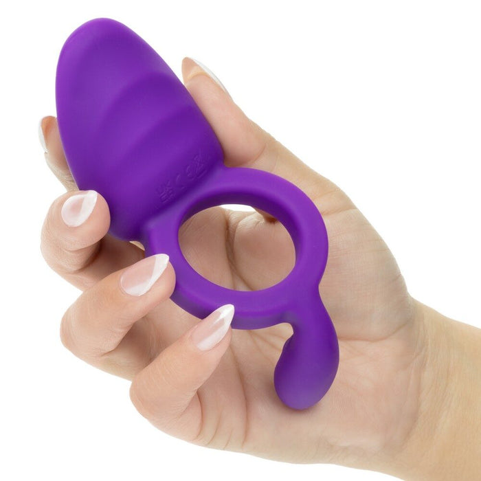 Hand holding a purple silicone ring with a white background