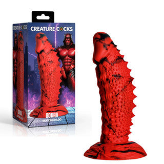 Creature Cocks Gojira silicone dildo by XR Brands in red and black with textured monster-inspired detailing and suction cup base, shown alongside fantasy-themed retail packaging.