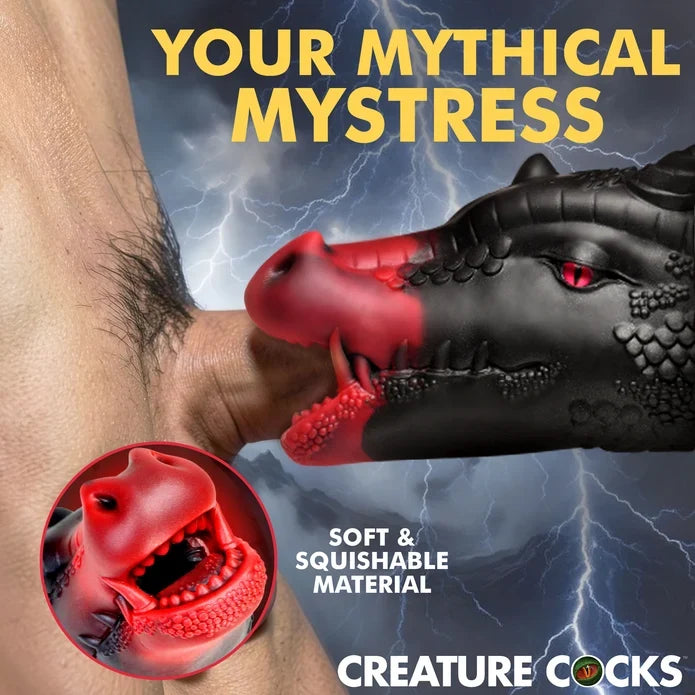 Promotional graphic for a black and red dragon-shaped adult novelty toy being inserted into a person's penis, with lightning background, large yellow text reading 'YOUR MYTHICAL MYSTRESS,' a circular inset close-up of the red mouth area, and the brand name Creature Cocks at the bottom.