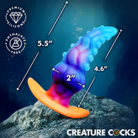 Colorful silicone anal plug with measurements on a dark background, featuring the brand 'Creature Cocks'.