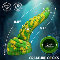 A green and yellow striped silicone crab claw toy for aquariums, shown with dimension lines indicating stretched and unstretched measurements, on a dark blue underwater-themed background.