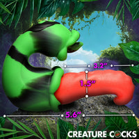 Green and red creature cock with measurements against a jungle background