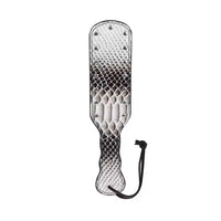 A textured paddle with a snakeskin-patterned design, metal studs, and a black wrist strap, shown on a plain white background.