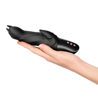 Black handheld vibrator held in a hand on a white background