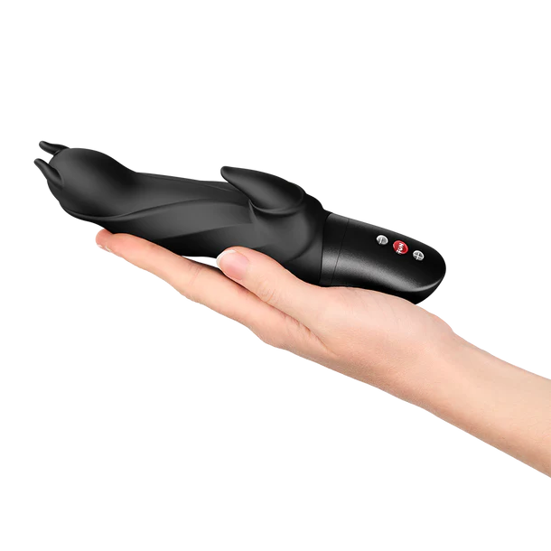 Black handheld vibrator held in a hand on a white background