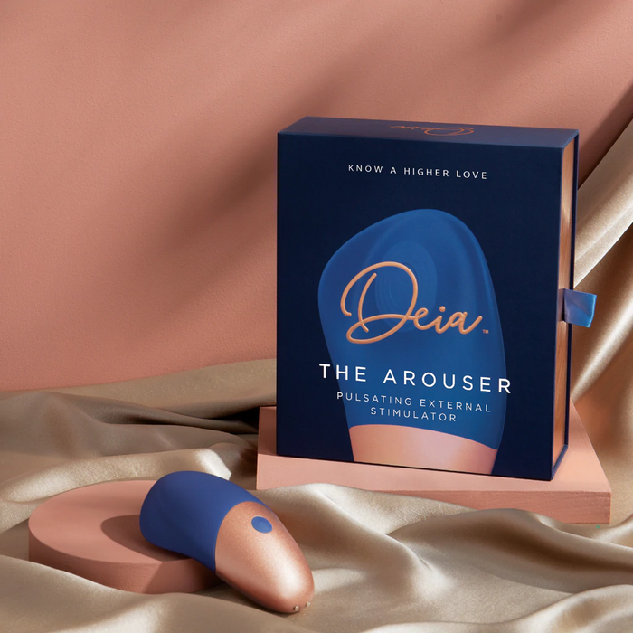 Deia The Arouser pulsating external stimulator packaging on a beige fabric background