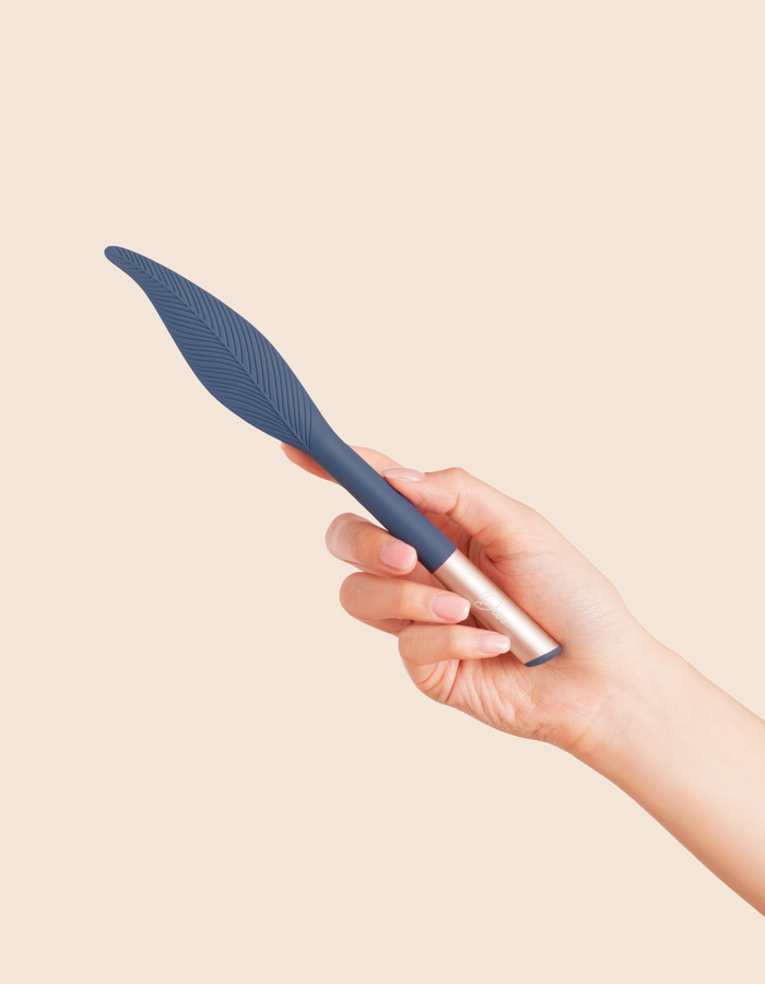 navy feather vibrator held in a hand