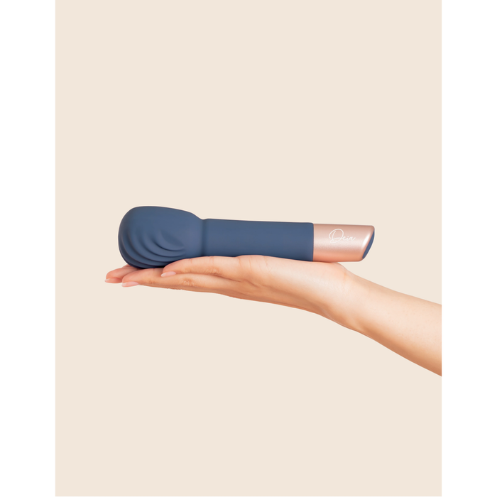 navy vibrating wand held on palm of a hand