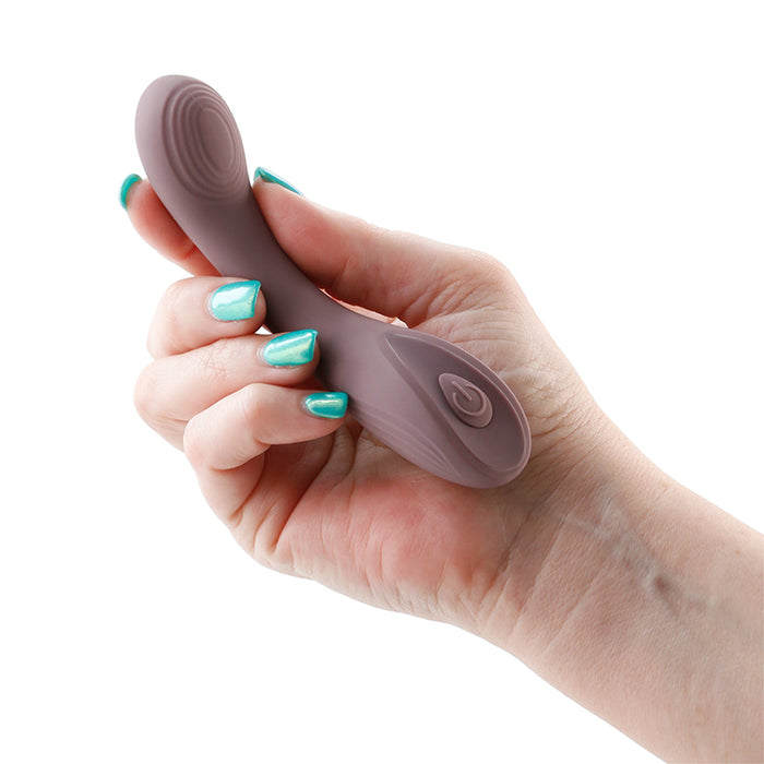Hand holding a purple vibrator on a white background