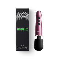 A black DOXY GO ultra compact wand massager shown next to its black packaging box with green branding, on a clean white background.