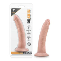 a beige penis shaped dildo with a suction cup base shown next to its plastic packaging