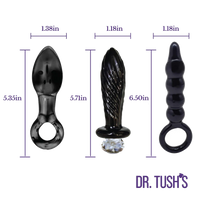 Three black adult novelty toys with dimension labels and purple measurement lines on a white background. The products include a curved glass piece, a textured cylindrical piece with a clear rhinestone at the base, and a ribbed curved piece with a ring.