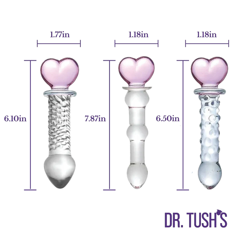 Three clear glass heart-shaped dildo shapes with dimension labels in purple text on a white background, with the brand name DR. TUSH'S at the bottom right.