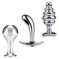 Set of three metallic butt plugs on a white background