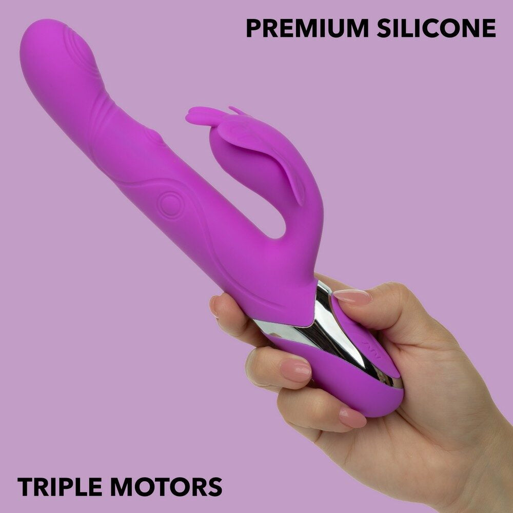 Purple silicone vibrator with triple motors held by a hand on a pink background