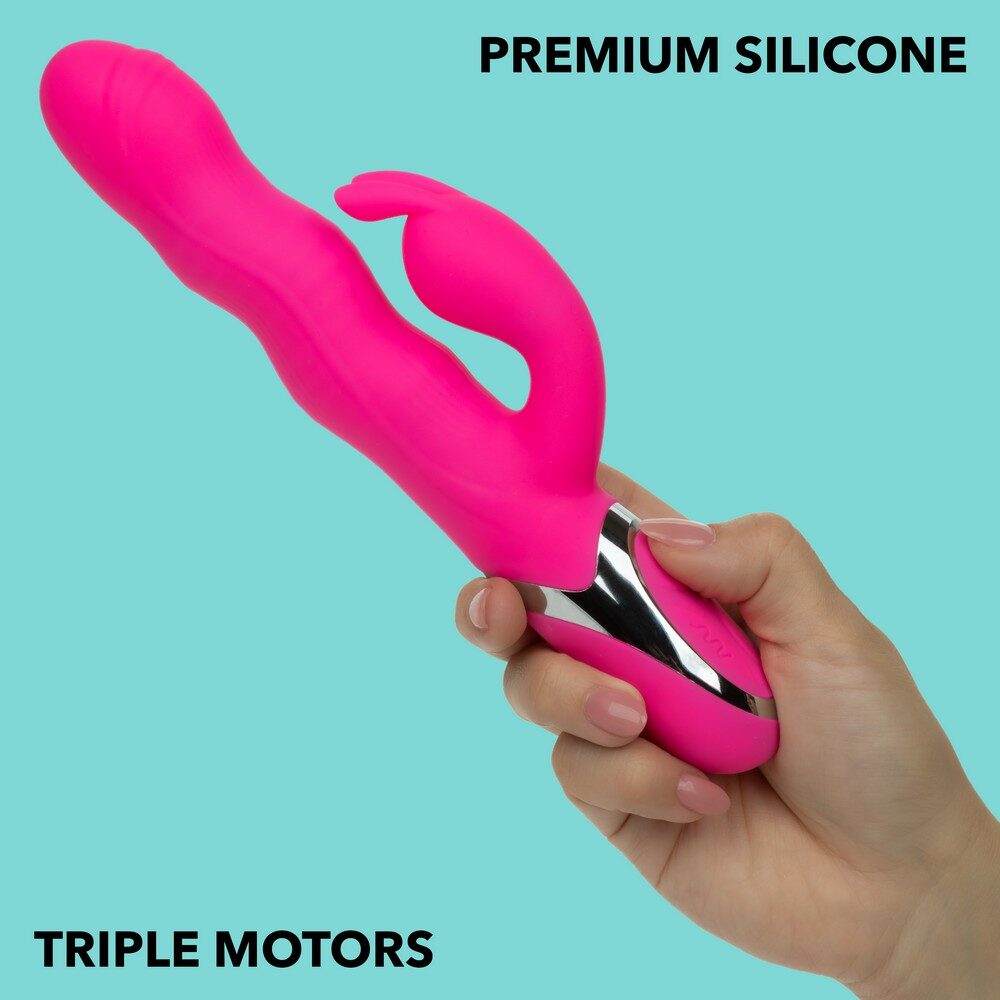 Pink silicone vibrator with triple motors held by a hand on a light blue background
