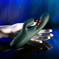 green curved vibrator with metal flicker with clitoral stimulation on colored background held in hand