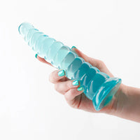 teal ombre dildo with riples from top to bottom base, smaller on top, wider on the bottom, held in hand