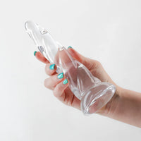 clear dildo with swirl ridges, smaller on top, wider on bottom base, held in hand