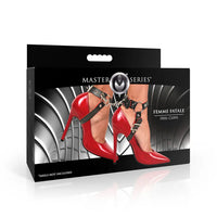 Box of Master Series Femme Fatale Heel Cuffs with red high heels and black straps on a white background.