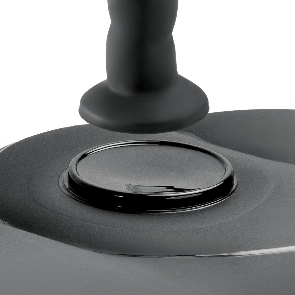 Close-up of a black dildo suction spot on and inflatable love seat a white background