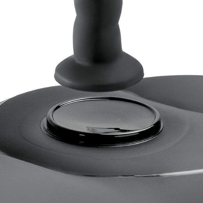 Close-up of a black dildo suction spot on and inflatable love seat a white background