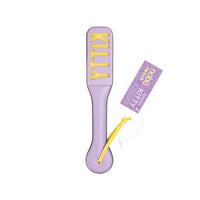 A lavender purple paddle-style accessory with the word 'KITTY' in raised yellow letters, shown on a white background with a matching purple hangtag.