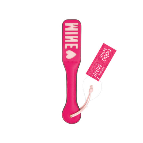 A bright pink strap-on paddle with 'MINE' and a heart printed in white, attached to a pink retail tag 