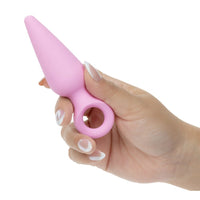 Hand holding a pink booty probe shaped object against a white background