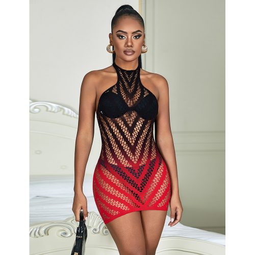 Woman wearing a black and red ombre fishnet dress in a bedroom setting