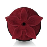 A dark red silicone flower-shaped masturbator insert with a central hole, shown on a black circular base against a white background.
