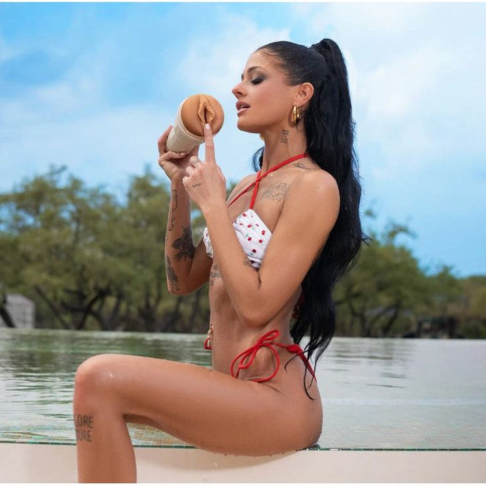 adult star ryan reid sitting beside pool, wearing a red and white bikini holding her molded fleshlight vagina masturbator 