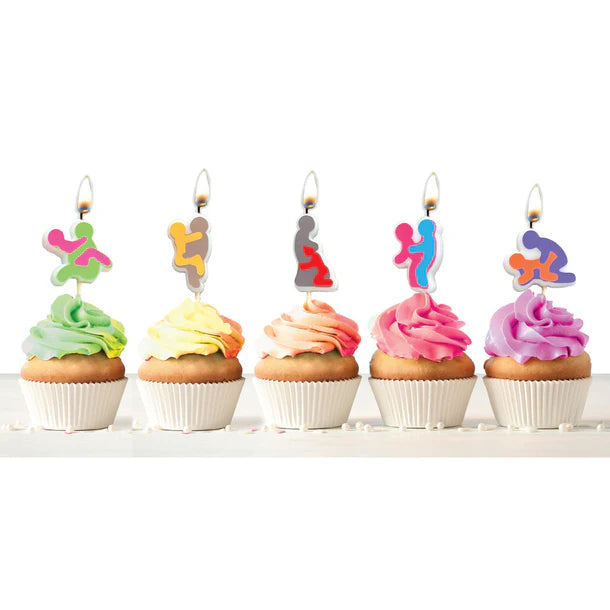 Five cupcakes with colorful frosting and unique shaped sex position candles on a white background