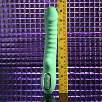 Green full throttle vibrator i with a ruler for scale against a purple grid background