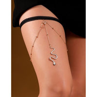 Leg with snake-shaped jewel on a plain background