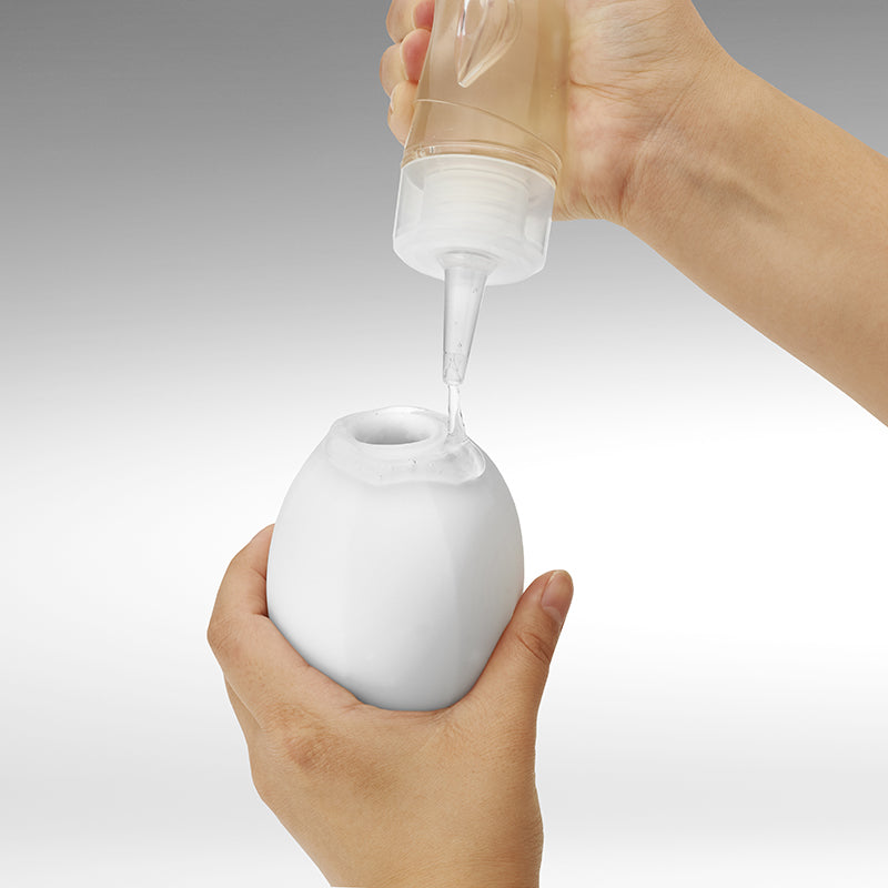 white textured masturbator with personal lubricant being poured on to the opening