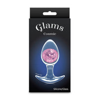 Glam's Cosmic glass anal plug in pink packaging with a clear silicone and glass item on a black background.