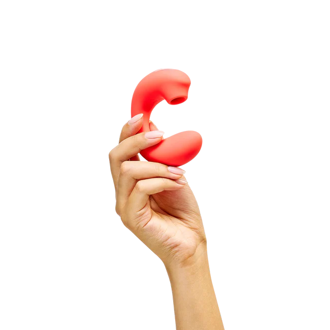 Hand holding a red silicone clitoral vibrator toy on a white background