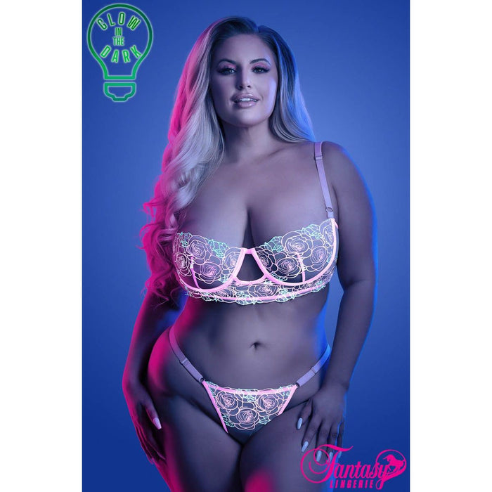 blonde female standing with pink uv light floral bra & panty