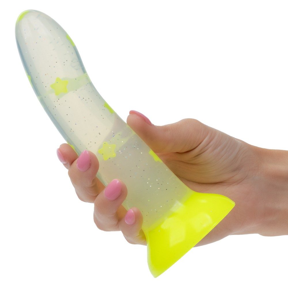 Hand holding a white and yellow dildo with star patterns on a white background