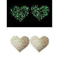 Heart-shaped glittery pasties with a black background